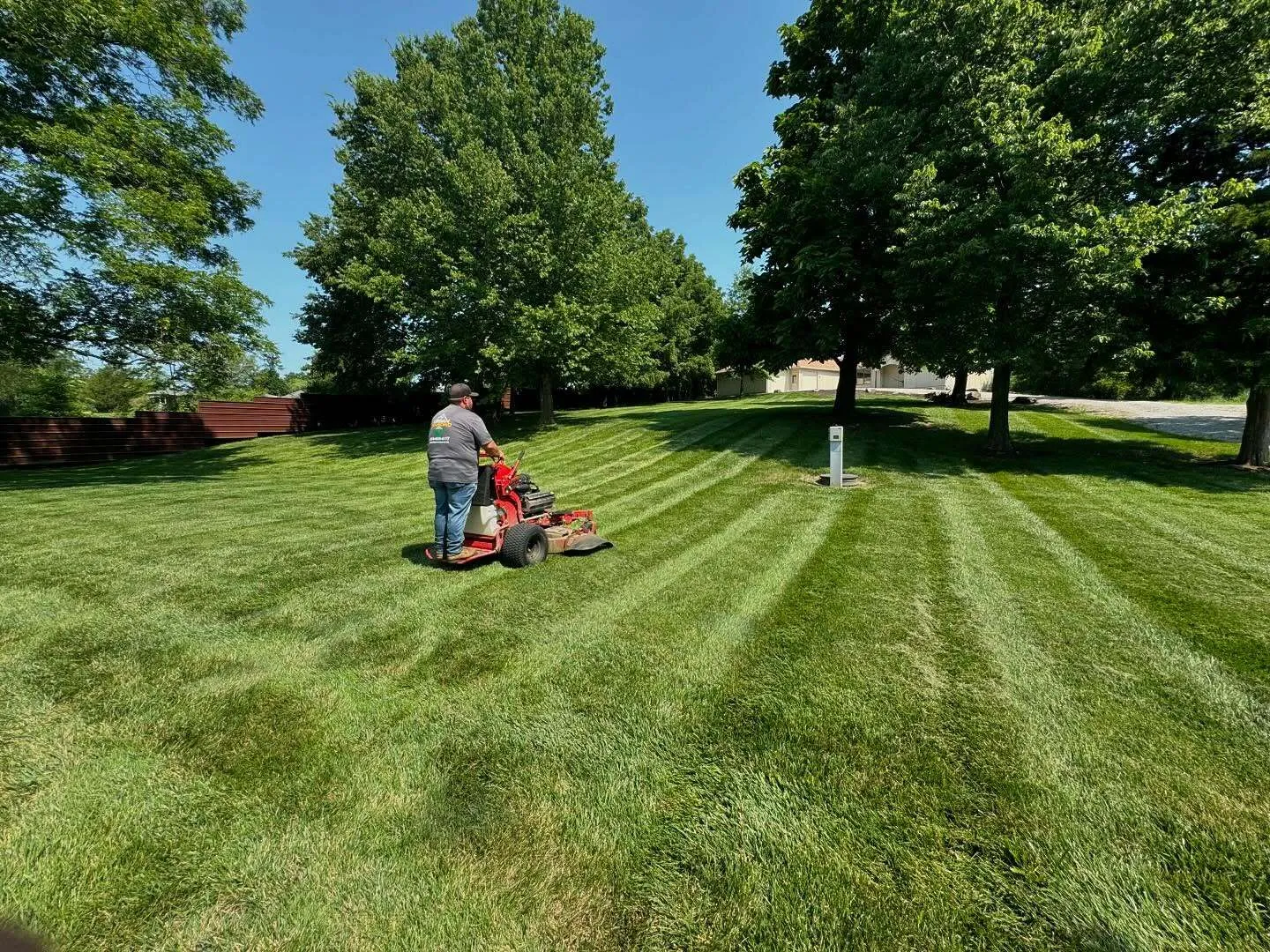 Urban Diamond team member mowing with visible stripes