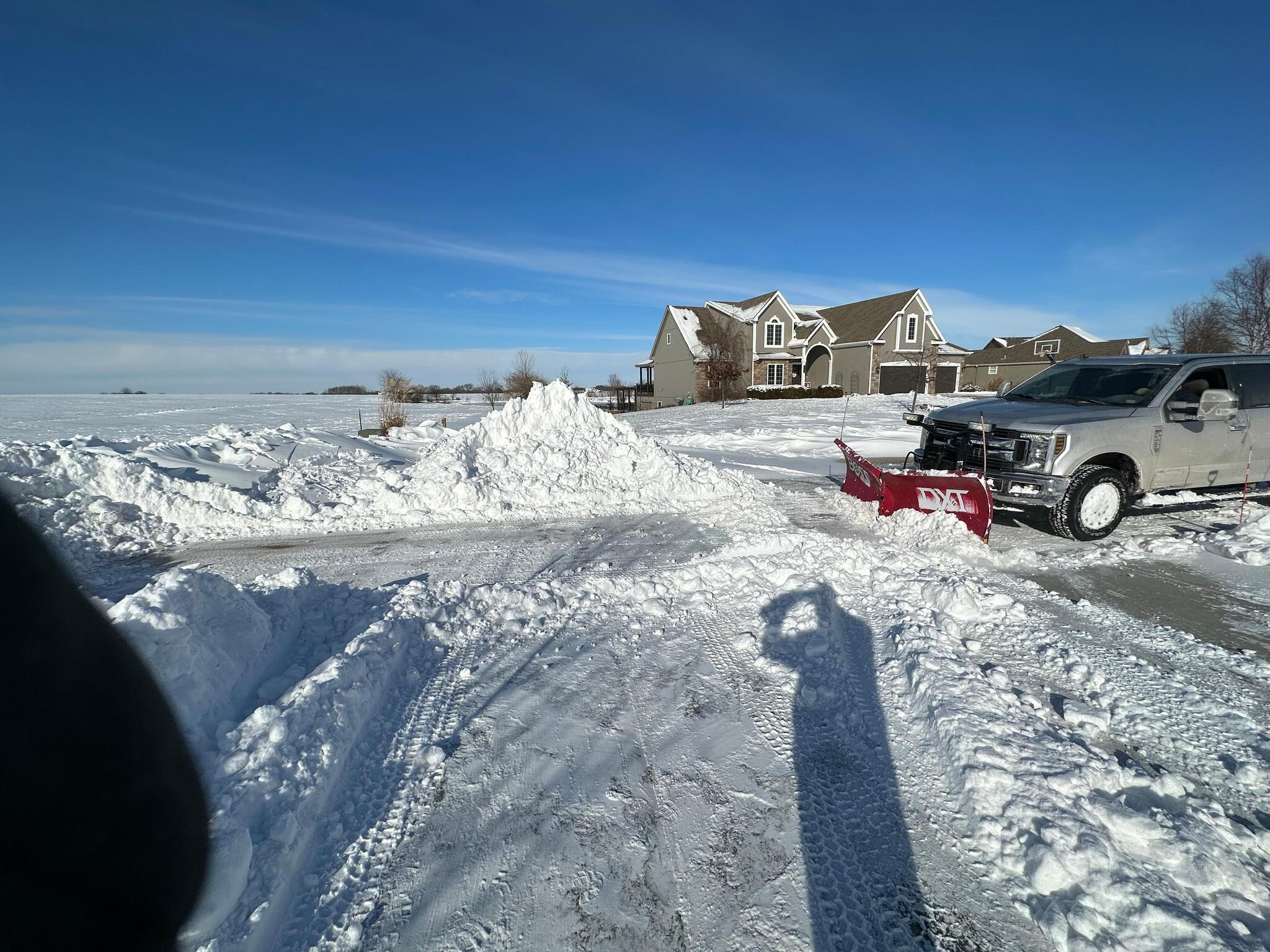 Commercial snow removal crew clearing a parking lot at dawn